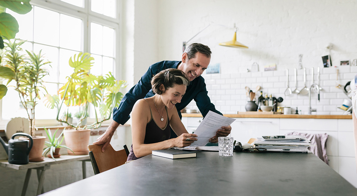 Two Covered California members review information at their kitchen table.