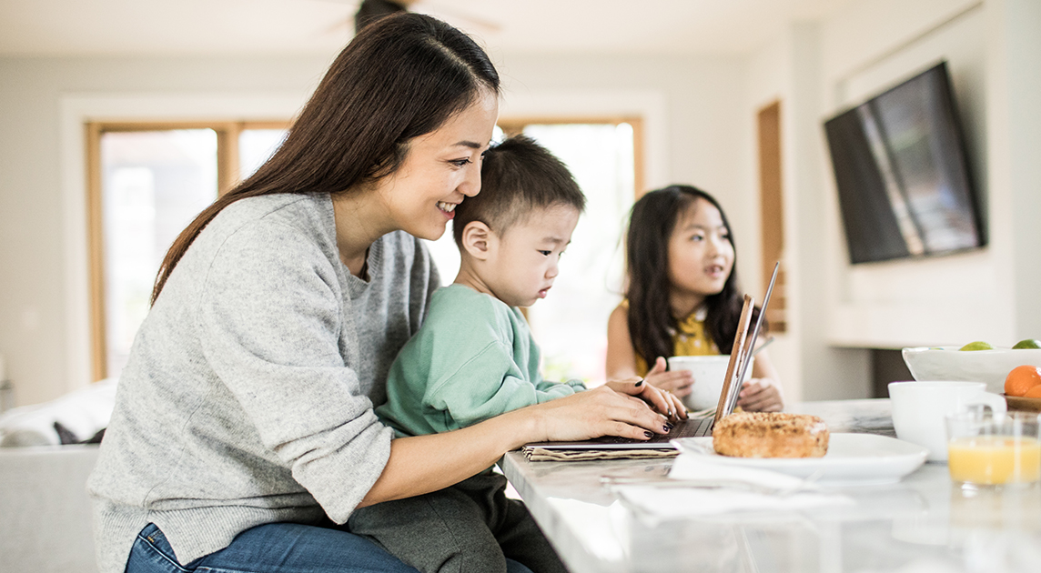 A Covered California member and mom researches health plans online with her kids.